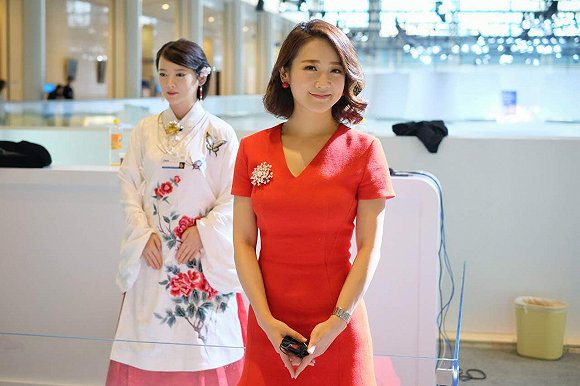 人形機器人“佳佳”(左)與雙語主持人、艾問傳媒創(chuàng)始人艾誠(右)